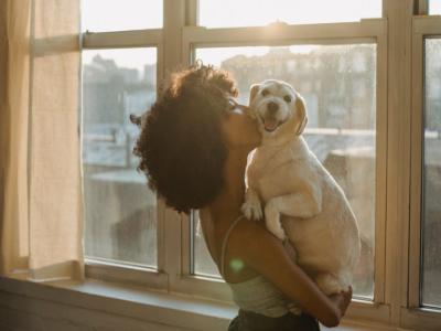 a woman kissing a dog 